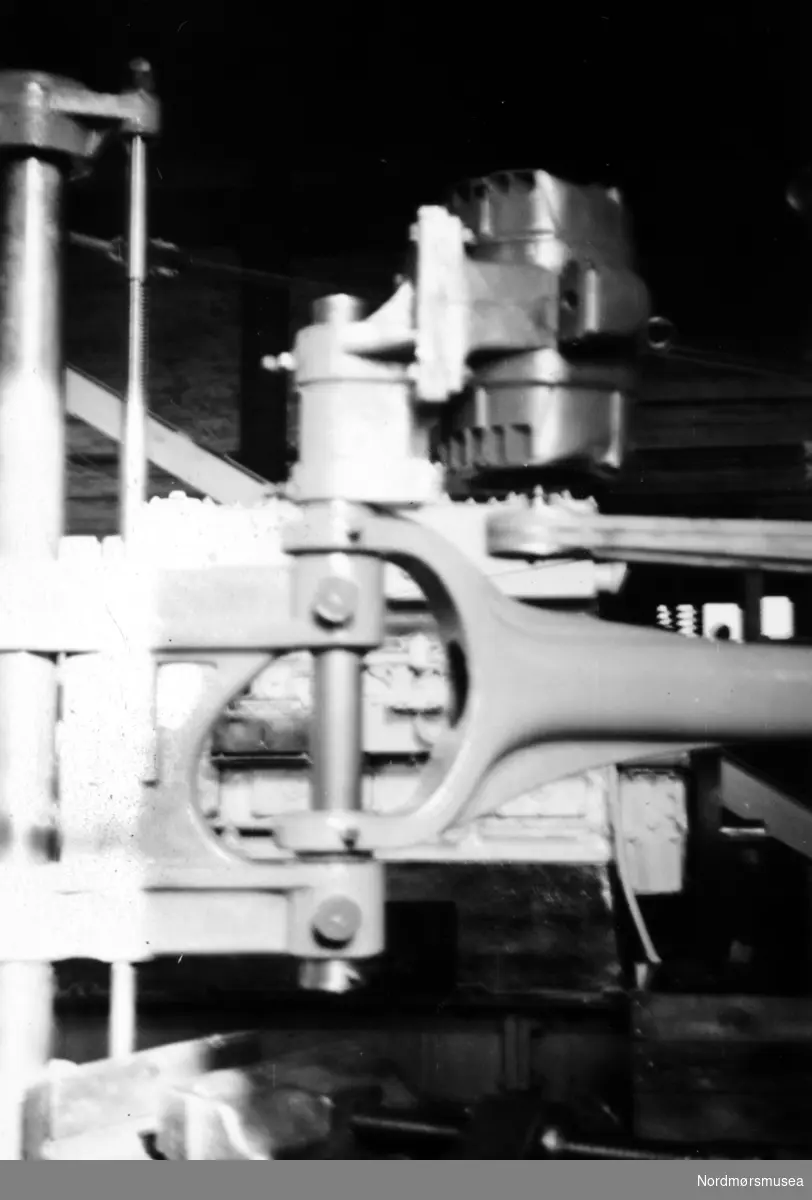 Bildet viser steinslipemaskinen som ble utviklet og produsert ved Storviks Mek. Verksted i maskinverkstedet. Maskinverkstedet ble bygget etter brannen i februar/mars 1911 og revet etter 1980.

Dette er den nyeste typen med kilremsdrift og elektromotor påbygd. Disse ble levert i stort anntall til steinslipeindustrien på Eide. På bildet ses festeanordningen og den påbygde elektromotoren oppmontert i maskinverkstedet ved verkstedet. Kilde/tekst: Peter Storvik. Fra Nordmøre museums fotosamlinger.



