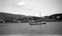 To biler om bord i en fraktebåt. Kulturlandskap i bakgrunn. 