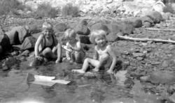 Portrett av tre barn ved strandkanten. Dette er trolig barne