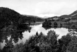 Et vann med jorder og gårdsbruk på høyre side. Kan det være 