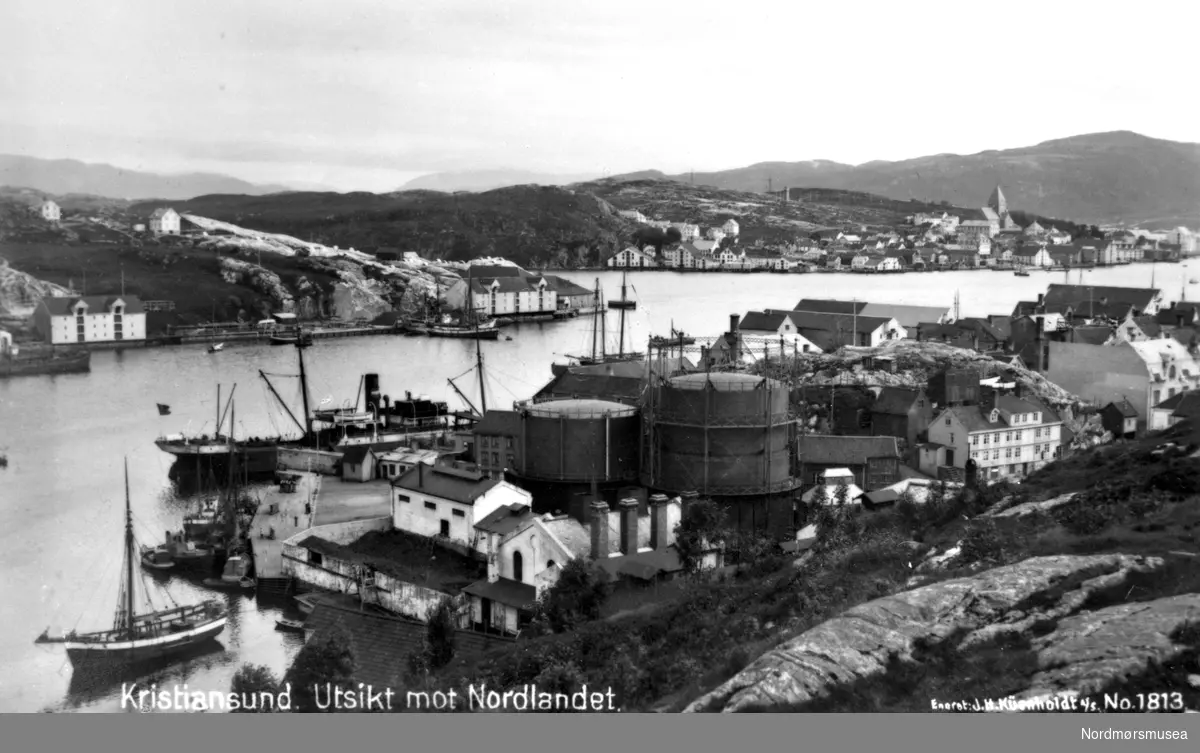 Kristiansund: Gassverket i Vågen, Fosnagata, Vedkaia. Hjelkrembrygga hvitmalt (Goma). Nordlandet bak, ca 1915. Foto: Küenholdt nr 1813. Fra Nordmøre Museum sin fotosamling.