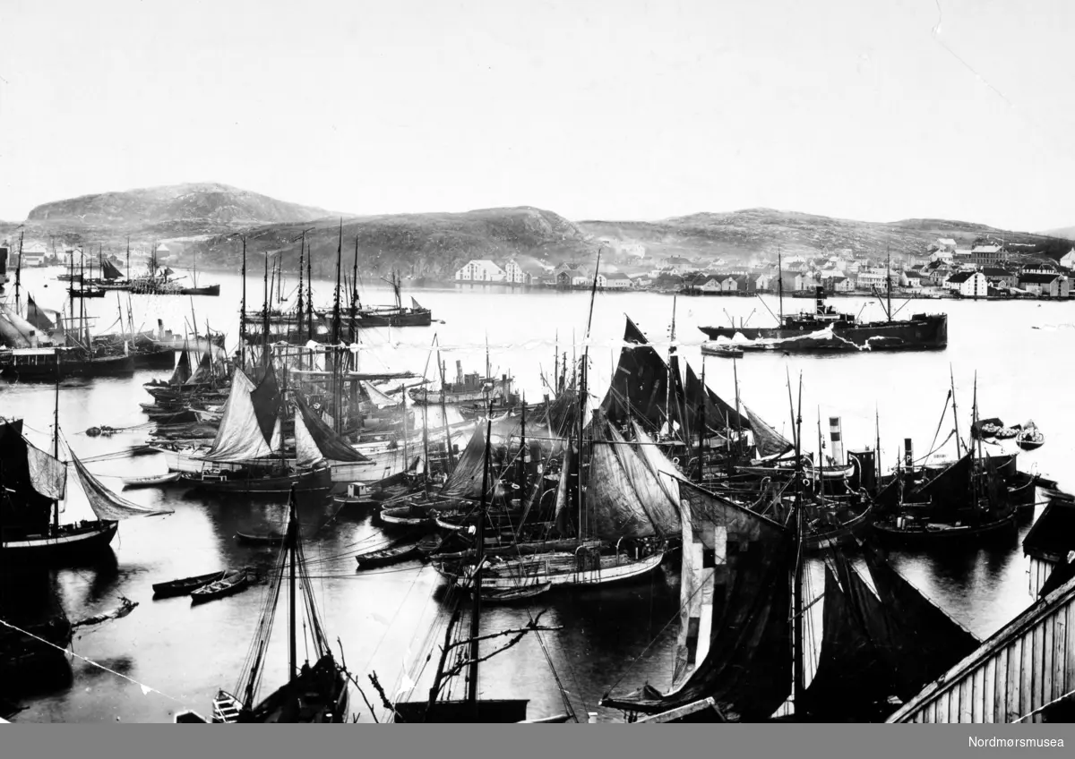 Eldre foto med utsikt over Johnsenhuken, sett fra området rundt Blixhammeren. Her ser vi havnen full av seilbåter av alle slag, med Nordlandet på andre siden av havnebassenget. Fra Nordmøre Museums fotosamlinger.
