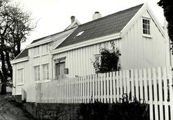 Foto av et eldre hus med stakittgjerde. Trolig i Kristiansun