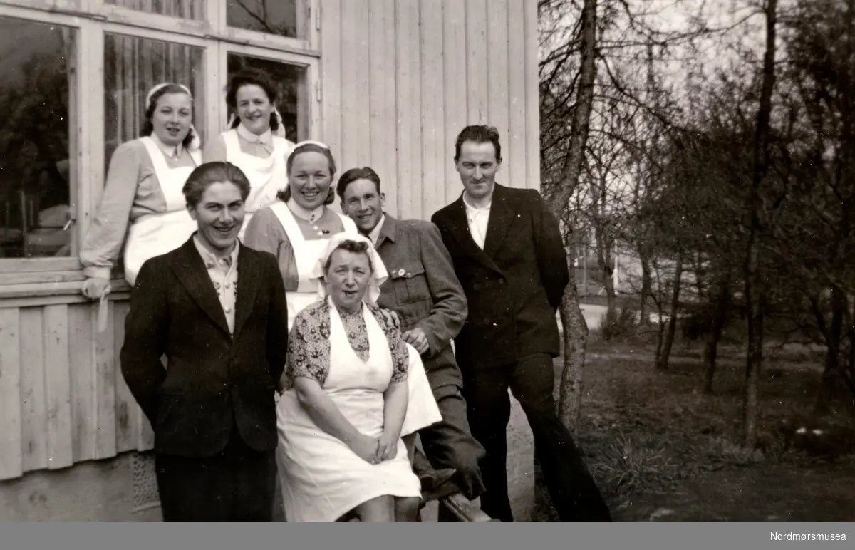 ";Brakke tid";. Foto fra en gruppe mennesker utenfor røntgenbrakken ved det gamle sykehuset i Kristiansund. Det er Christine Majorie Knudtzon g. Waagbø vi ser som nummer 4 fra venstre (nr. 2 i rekke 2).
Bildet kan trolig dateres til frigjøringsdagen i 1945, basert på de andre bildene i permen. Fra Ida M. Knudtzons fotosamlinger, nå en del av Nordmøre Museums fotosamlinger.
