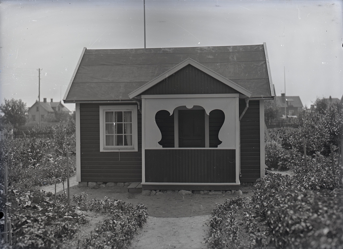 En stuga vid Kalmar södra koloniområde, fotograferad omkring 1930. Kalmar södra koloniförening grundades 1917 och har idag 105 kolonilotter. Området ligger strax söder om länssjukhuset i Kalmar med huvudingång från Stensbergsvägen.
