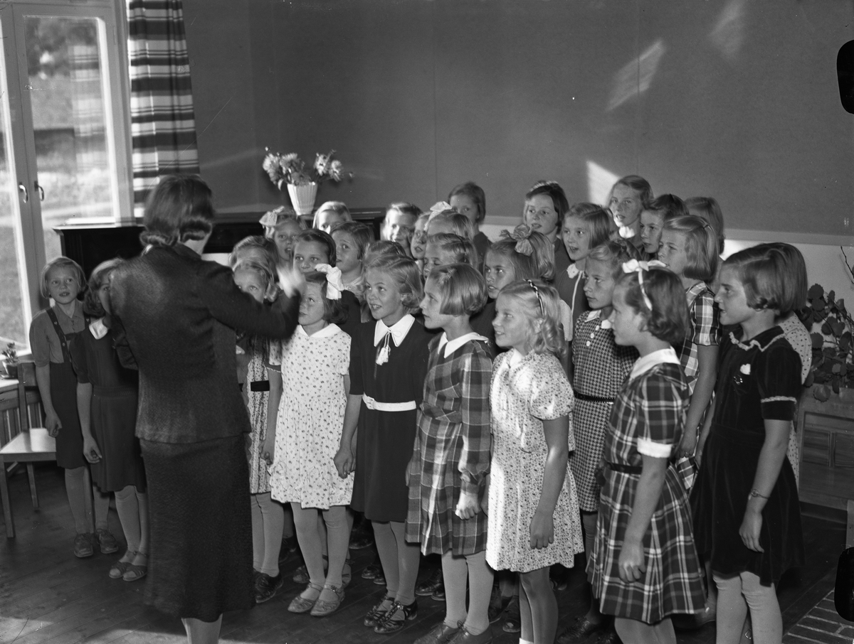 Körsång med flickkör under ledning av Gunhild Lindell i vid invigningen av Peterslunds barnstuga, Fålhagen
