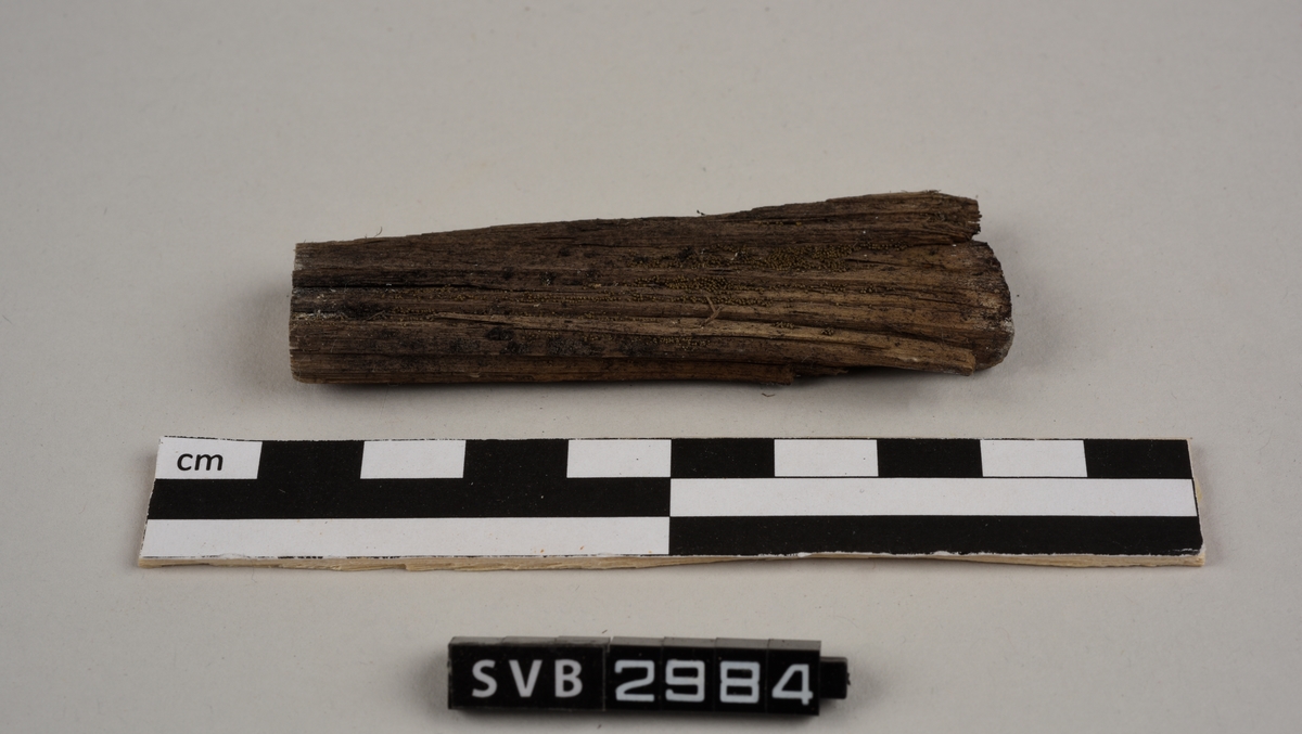 Tregjenstand med tilnærmet rundt tverrsnitt. Tremateriale er tørt og sprukkent. Det er 2 løse deler. Det er en lapp på undersiden med russiske tall og bokstaver.