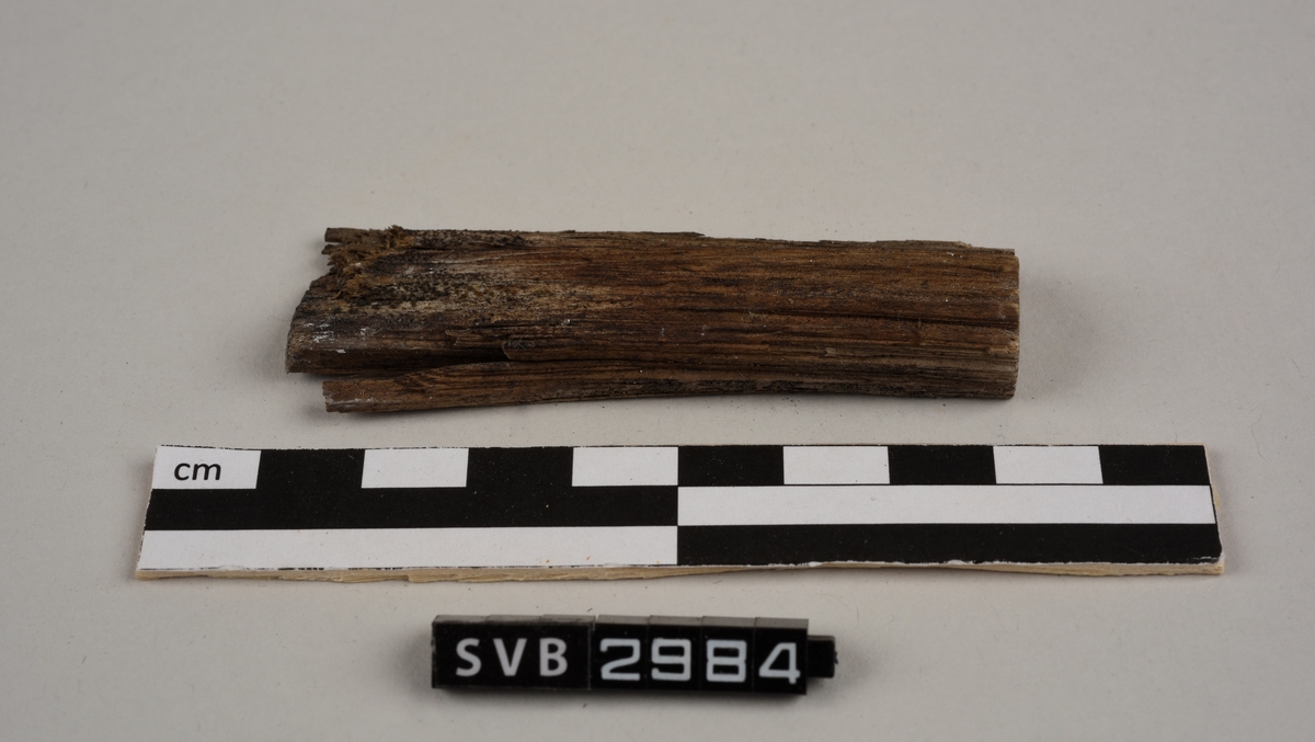 Tregjenstand med tilnærmet rundt tverrsnitt. Tremateriale er tørt og sprukkent. Det er 2 løse deler. Det er en lapp på undersiden med russiske tall og bokstaver.