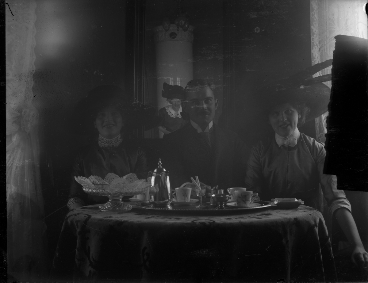 David Brundin vid kaffebordet, omgiven till vänster av Gertrud och Naemi till höger, systrar till Elna Brundin som syns i spegeln.