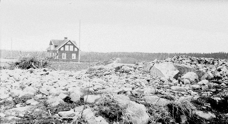 En hällkista i Löpanäs, Rottne. I bakgrunden syns ett bostadshus.