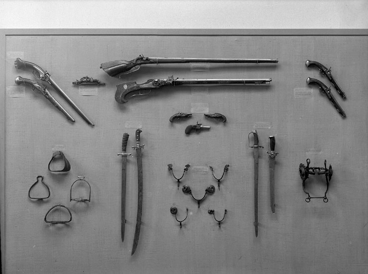 Ett antal stigbyglar, gevär, sablar och ryttarpistoler m.m. i den 
Historiska avdelningen på Smålands Museum.