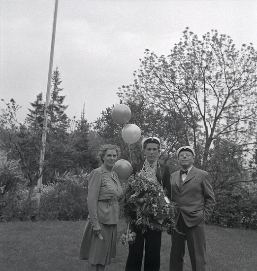 Tegner, 1947. Karl-Bertil Tegner (1927-   ) med sina föräldrar, Yelverton och Gertrud Tegner, i trädgården till Trädgårdsgatan 10, Växjö. Yelverton Tegner (1877-1961), stadsläkare i Växjö. G.m. Gertrud T.(1886-1973).
