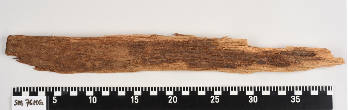 Deler av en rektangulær gravkiste. Det er kistebunnen, kistelokk, kistesidevegger og deler av hodeendegavlen.
Kistelokket er laget av et flatt og rektangulært bord som er laget av ett stykke tre. Bordet er sterkt fragmentert.
Kistesidene er i litt bedre tilstand. Bordene er avlange, rektangulære og laget av et stykke tre hver. Bordene ble festet med spiker til kistebunnen. Det er en spiker igjen i venstre sideveggen. Begge sidebordene har langsgående sprekker og er delvis brudd i flere deler.
Kistebunnen er laget av et flatt og rektangulært bord som er laget av ett stykke tre. Det er flere langsgående sprekker og flere kvisthull. Fargen er mørk brun med enkelte lysere brune partier i hodeenden.  I begge kortender er det rester etter hodegavlen og fotendegavlen og langs venstre siden er det rester etter kisteveggen. Hodeenden er bredere enn fotenden.
Hodeendegavlen er laget av en tykkere rektangulær trekube. Den har brudd opp i flere deler både på grunnen av nedbrytingen og under utgravningen.