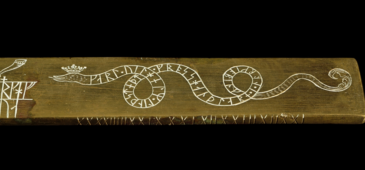 Kalenderstav i form av en svärdsformad runkalender. Tillverkad av mässing i Norrköping år 1743. Plan kavel med dubbelt grepp och ringformig knapp. Kalender på klingans båda sidor. Vid spetsen på klingans båda sidor en krönt drakslinga med runor. Transkription: HINRIK IAKOB SIUERS LIT RITA STAF DINO I NORKOBING. IAKOB MOERLING RISTI RUNOR OK MARKADI samt KARL WILHELM LINDSTEDT GROSSHANDLARE I NORKIOBINK. Runt knappens hål med latinsk skrift: 1743 NORKIÖPING samt C.W. LINDSTEDT.