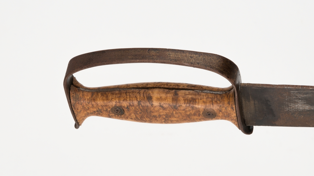 Hjemmelaget etterligning av en huggertlignende sabel med håndtak i tre og metall. Grov og rett avskåret enegget klinge.