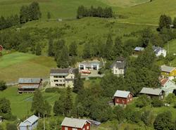 Follebu hotell. Tre-etasjes hvit bygning i vinkel. Rødt uthu