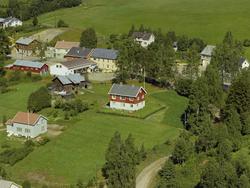 Samvirkelaget. Hvit lang bygning bygd sammen med drosjesentr