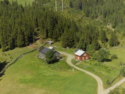 Haugland (Toproa). Rødmalt stue, umalt uthus. Hage med grønn