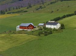 Myhre. Gårdsbruk. Hvit bygning, rødt uthus, vinkel og påbygd