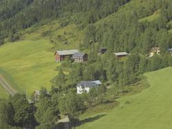 Gårdsbruk i ei li, stabbur, kvitt bolighus, skog, Østre Gaus