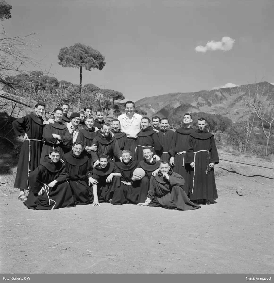Ett lagfoto på fotbollsspelande munkar, en munk i första ledet håller i en fotboll.