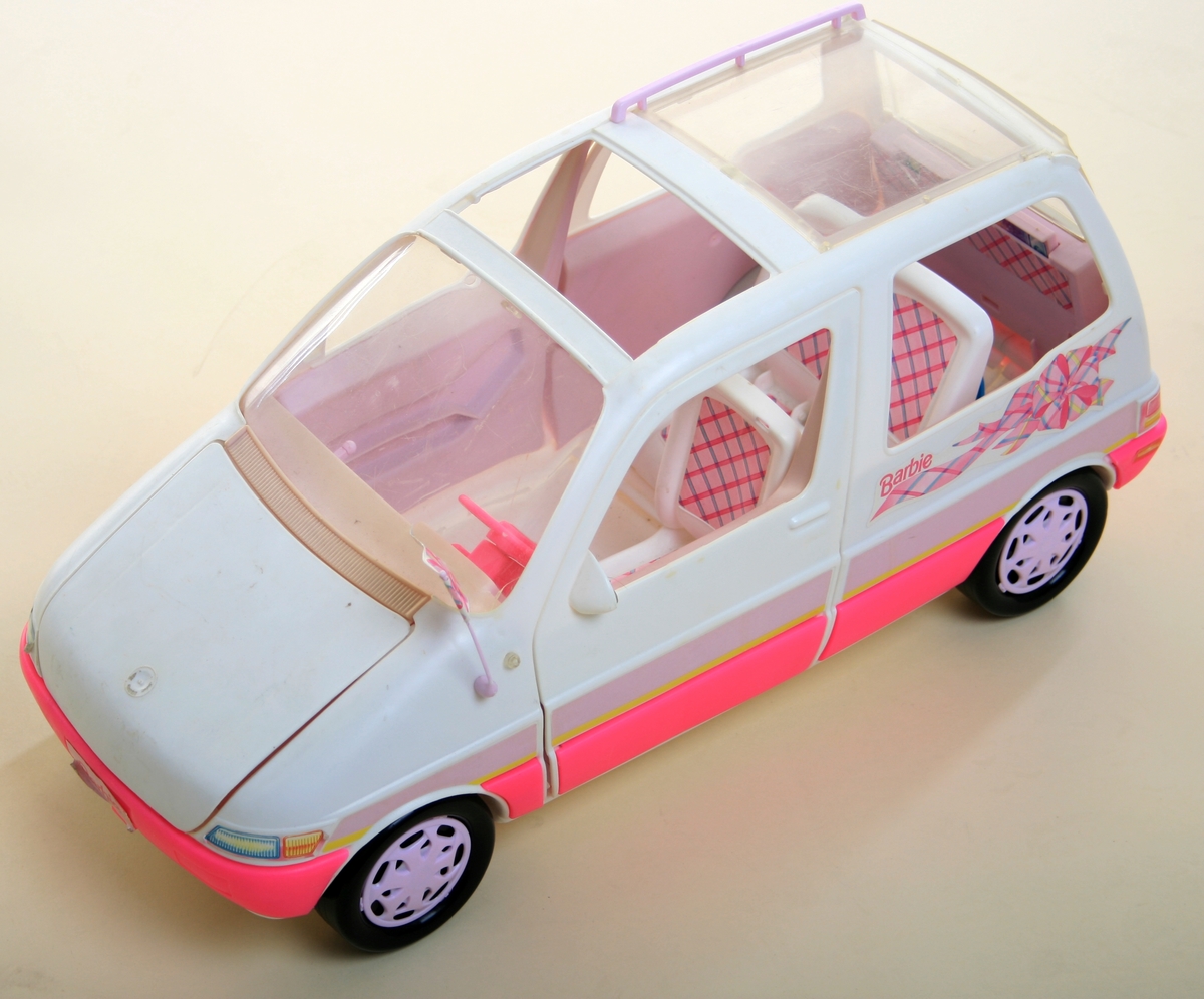 Lekebil av plast. Hvit og rosa karosseri, interiør med rosa-rutete seter, rosa ratt.  Sorte hjul. Flere deler mangler, bl.a. venstre forsete og takluke.