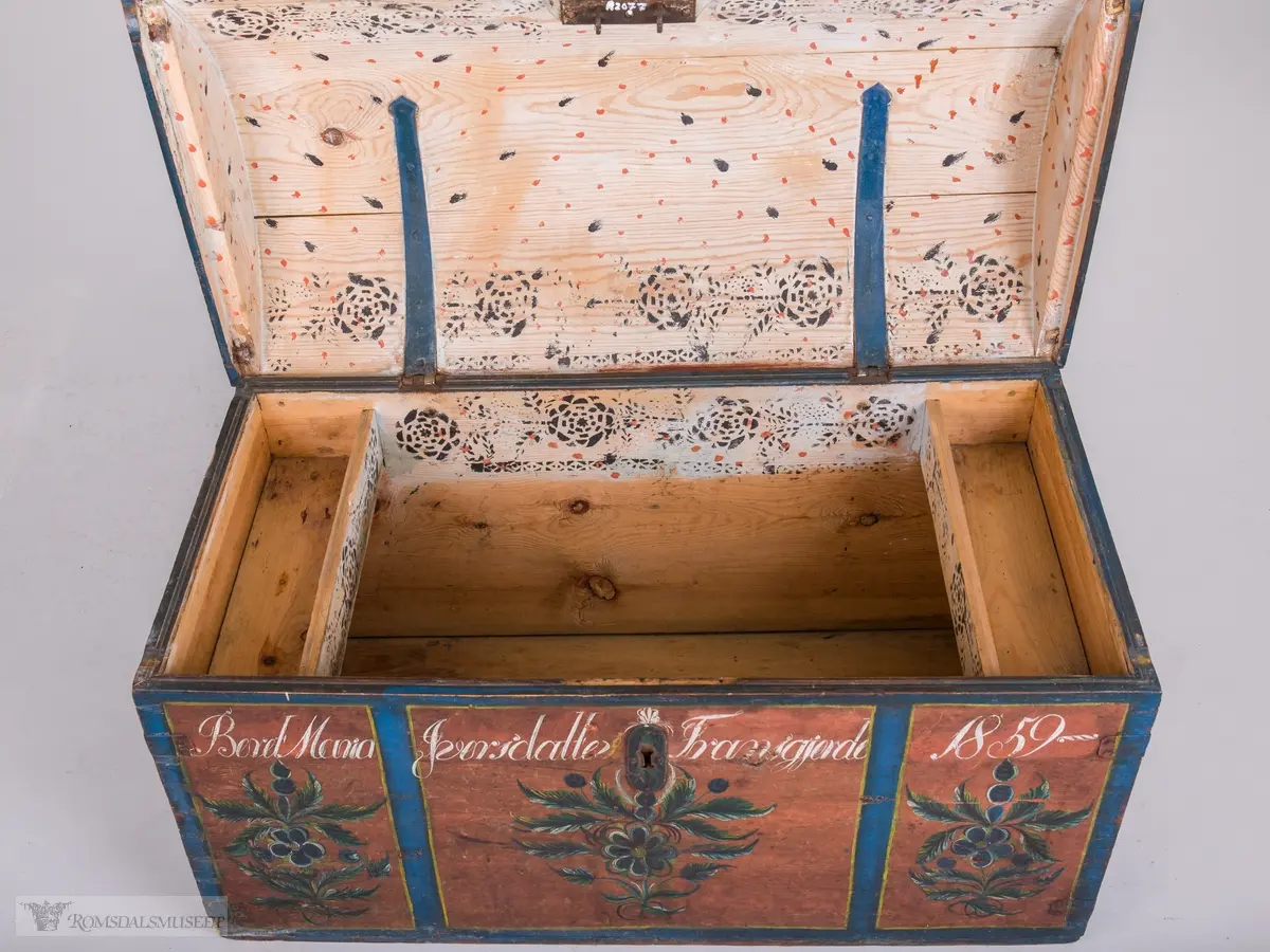 Kisten har oppdelte felt.  Felta er avgrensa med blå og gule kanter. Inne i felta: Rosemalt.  Farger i blått, grønt, gult, hvitt og sort.
Innvendig påtrykt mønster (Påsett farge) i mørkeblått og orange prikker.  Håndtak på hver side.