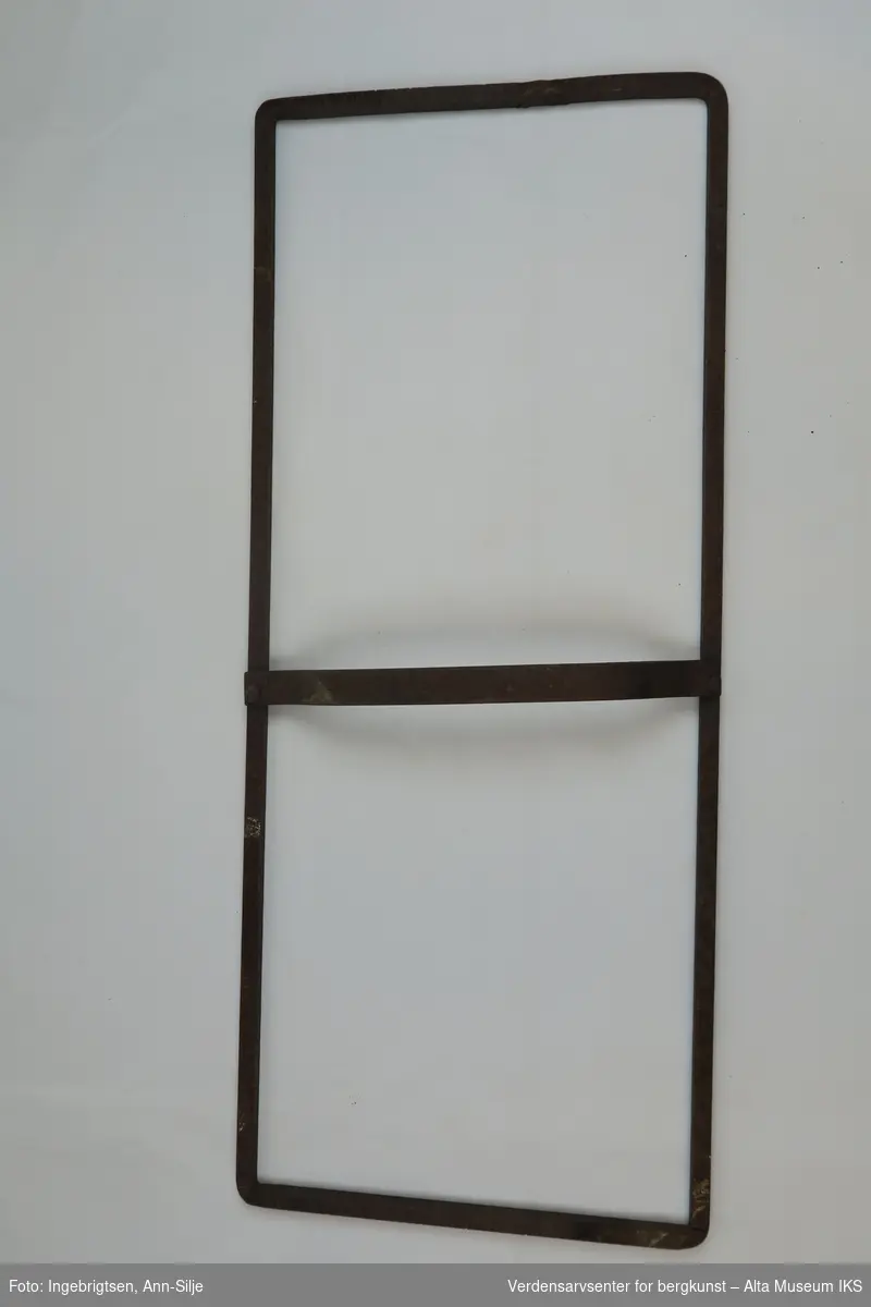 Rektangulær skifermål, med et enkelt tverrgående forhøyet metallstang i midten, som fungerer som håndtak.