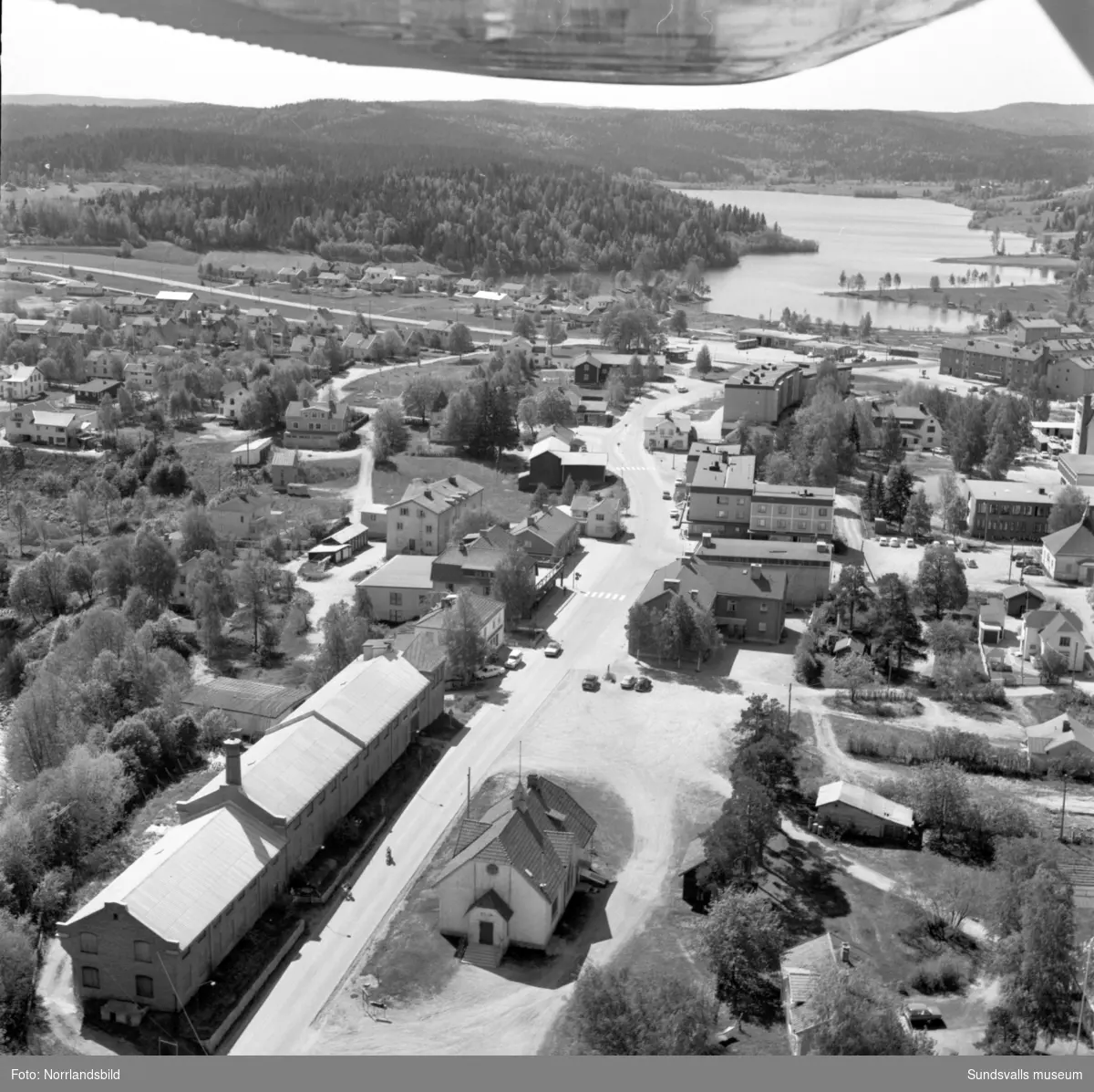 Flygfoton över centrala Matfors, södra sidan av Ljungan. Sköle-området där en hel del numera är rivet och ersatt av flerfamiljshus, skolan, Elim-kapellet, yllefabriken, Folkets hus, gamla och nya Tunahus.