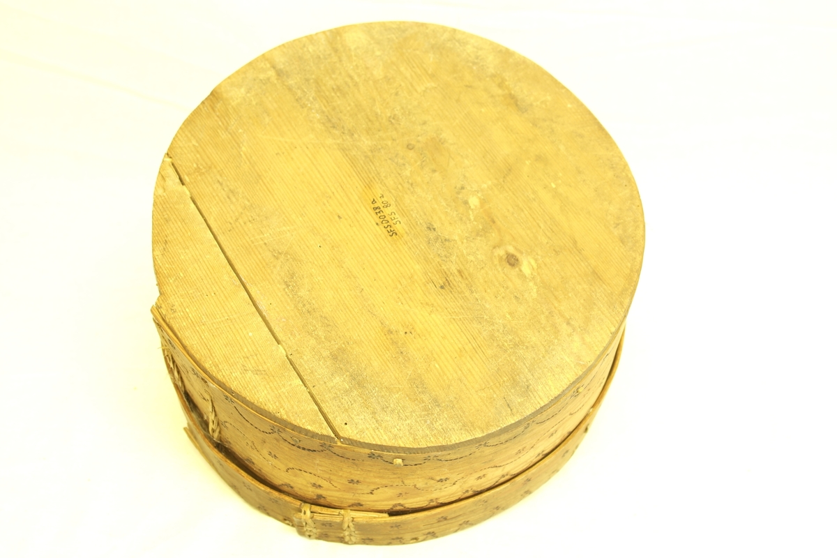 Smøreske i furu, bestående av eske (A) og lokk (B). Gjenstanden er spaltet, pusset og sydd sammen. 
A) Eska har brennornamentikk.
B) Laget av ett stykke, med en trjosk som kant. Lokket har brennornamentikk.