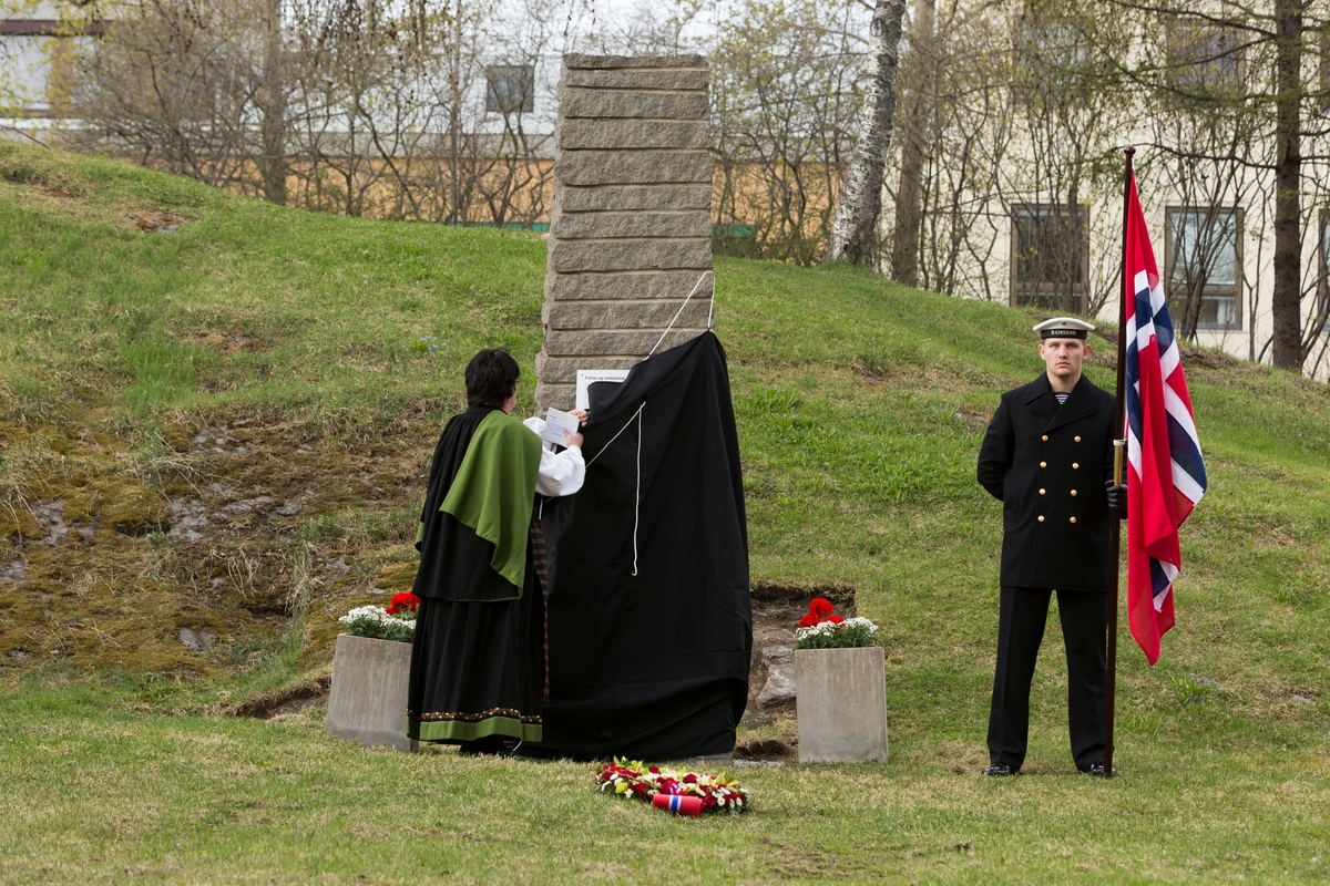 Ordfører Marianne Bremnes avduker minnesmerke. Til høyre står marinegast med flagg.