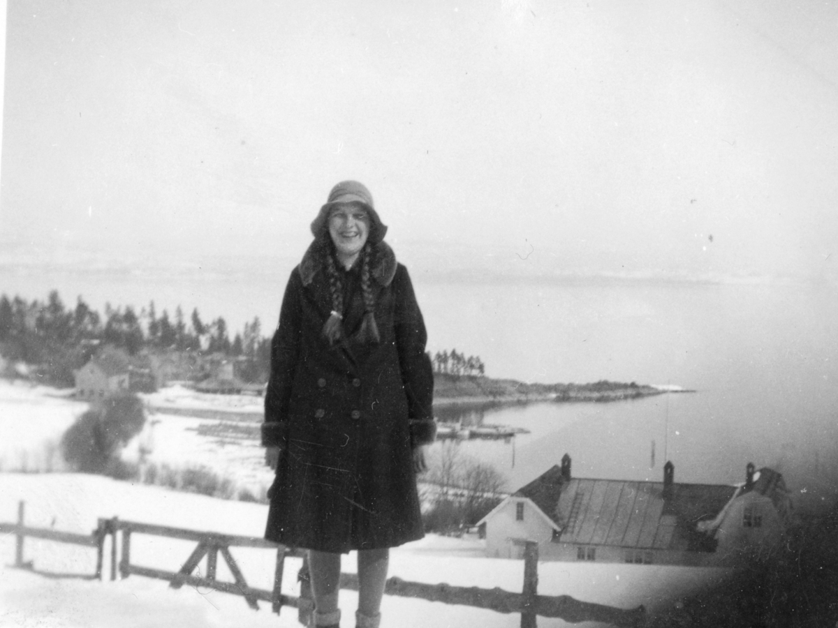 Mimi Rønningen f.1916 med plassen Østli og Bergevika i bakgrunnen. Fra Rønningen, Helgøya.