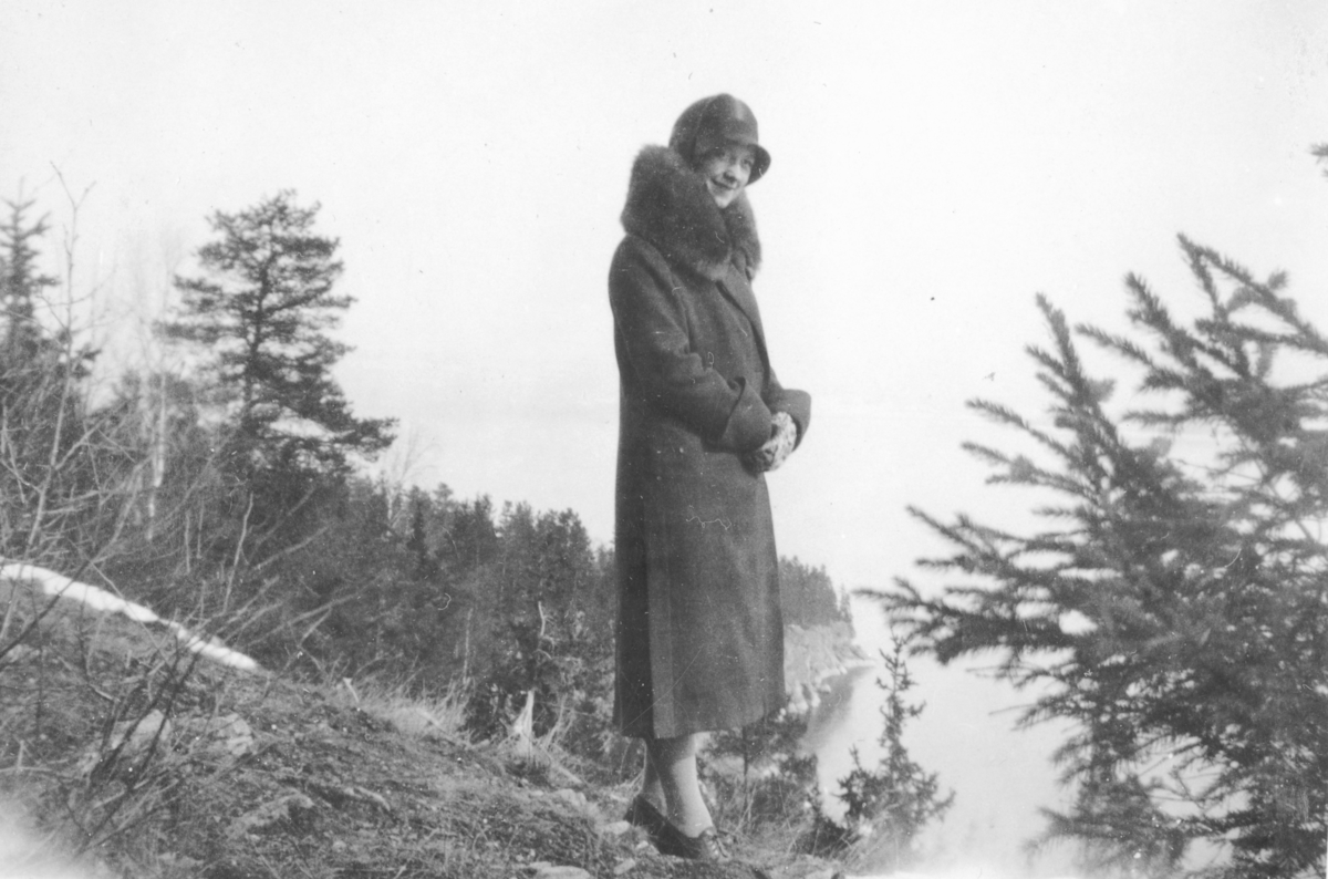 Anna Rønningen f.1909 på utsikten ved gamlevegen ned mot Bergevika, Helgøya med Storberget i bakgrunnen. Fra Rønningen, Helgøya.