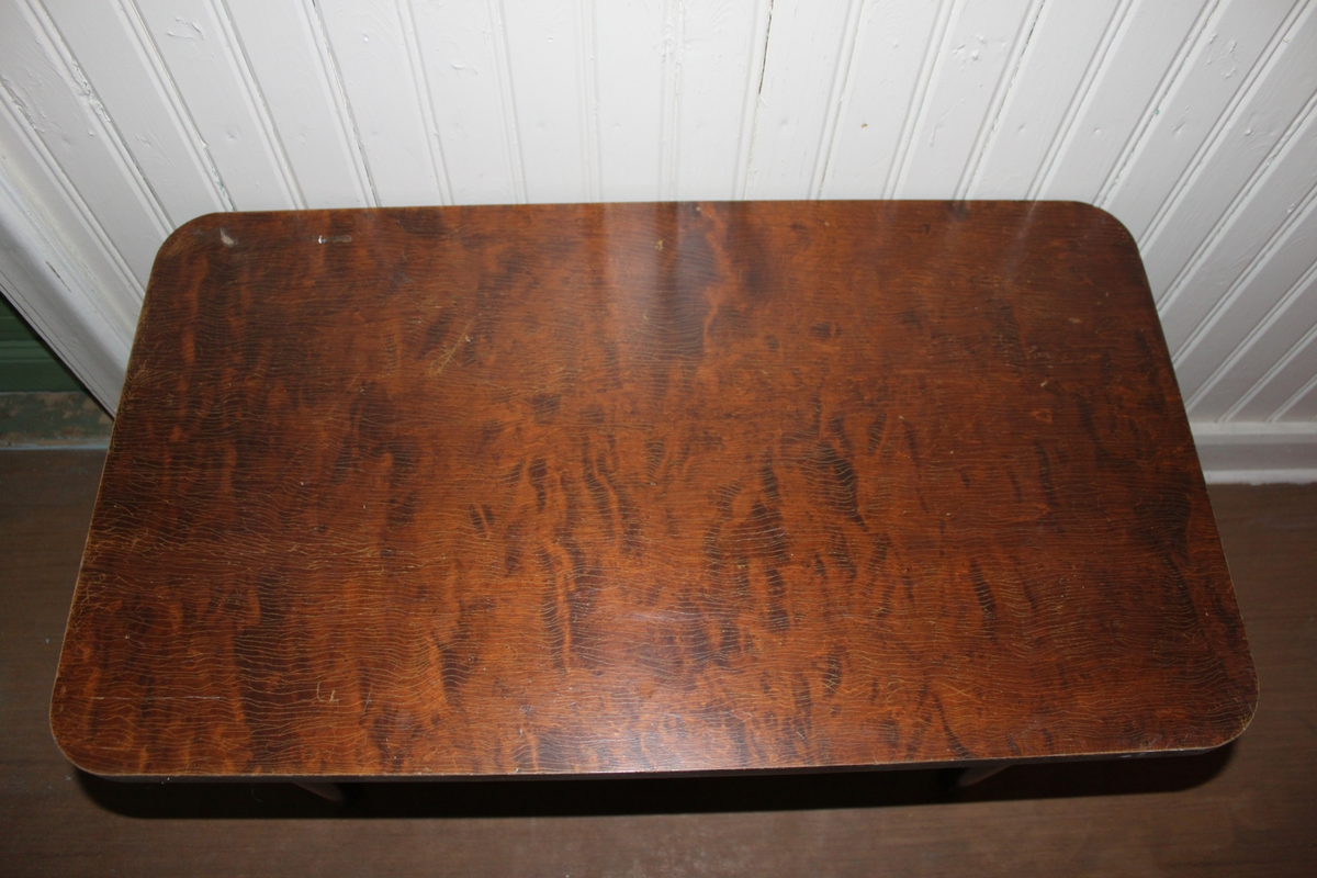 Fyrkantigt avlastningsbord med brun faner. Fyra ben.
