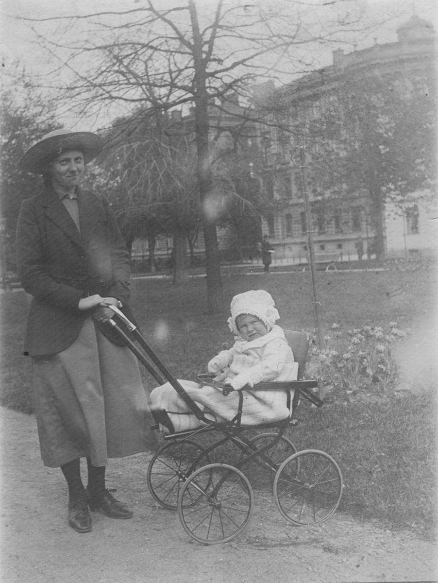 Bilden visar Gurly Axelsson (gift Johansson) som är ute och går med ett barn i barnvagn. Hon arbetade antagligen som barnflicka åt någon familj vid tillfället. De befinner sig i Järnvägsparken.
Gurly Axelsson är Birgit Pehrssons adoptivmor.