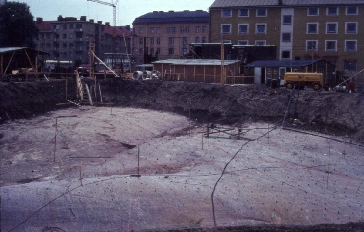 Bildtext: Domus under byggnad, i bakgrunden Drottninggatan-S:t Larsgatan.
