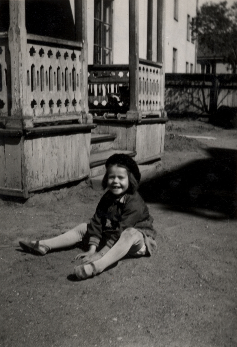 Bilden visar Inger Lilja, f. Andersson, sittandes på gården vid Drottninggatan 15. Det är sommar år 1942 och Inger är 6 år gammal.