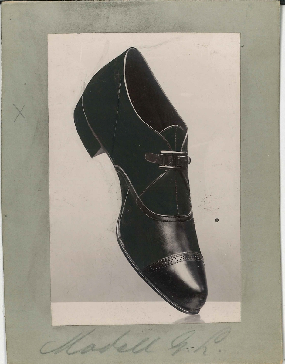 Fotografi av ett skodon. Damsko med spänne. Modell från 18-1900.

Använd som reklam på A F Carlssons skofabrik.

Ingår i en samling med 123 stycken kort i kartong.