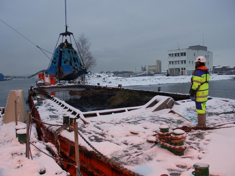 En arkeolog følger med på mudring av sjøbunn under Senketunnelprosjektet i Oslo.