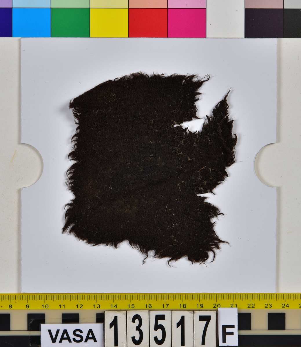 Textil.
20 textilfragment uppdelade på fyndnummer 13517a-j.
Fnr 13517a består av två fragment av ull vävda i tuskaft. Det mindre fragmentet är trekantigt, har varit valkat på insidan och har fållar med sömmar kvar. Det stora fragmentet har två bevarade originalkanter.
Fnr 13517b består av två fragment av ull vävda i 2/1-kypert.
Fnr 13517c består av två fragment av ull vävda i tuskaft. Det större fragmentet har ett hål i mitten. De är svarta av tjära och har troligen varit en del av en becksudd.
Fnr 13517d består av ett fragment av ull vävt i 2/1-kypert.
Fnr 13517e består av ett fragment av ull vävt i 2/2-kypert.
Fnr 13517f består av ett fragment av ull vävt i tuskaft.
Fnr 13517g består av 6 fragment av ull vävda i tuskaft. Två av fragmenten ser ut att ha varit valkade på ena sidan. Tre av fragmenten har vissa originalkanter eller -fållar kvar.
Fnr 13517h består av ett fragment av ull vävt i tuskaft.
Fnr 13517i består av 3 fragment av ull vävda i tuskaft. Fragmenten kan ha varit valkade på ena sidan. Ett fragment är ljusare i färgen än de andra.
Fnr 13517j består av ett filtat fragment av ull eller bäver. I en av kanterna finns hål efter en söm.






TEXTILDOKUMENTATION 2018:

Fyndnummer: 13517c
Kontextgrupp: HS5
Typnummer: HS5.1:1 (till höger i bild)

Fragment i tuskaftsvävd ull och ruggad/valkad med en mycket tät lugg. Fragmentet är rektangulärt, har uppfransade kanter och ett spikhål i mitten (3-4 mm). I mitten på ena sidan finns ett vagt fyrkantigt avtryck (28 x 25 mm) och på andra sidan ett ovalt avtryck (35x47 mm). Dessa avtryck är troligtvis efter en fyrkantig läderbit och ett runt skaft vilket talar för att detta fragment har tillhört en becksudd. Tyget har veckats och brustit mot avtrycket. Fragmentet har synliga rester av tjära/beck samt bastfiber som ligger ovanpå. Fragmentet är relativt mjukt.

TEKNIK
Trådsystem 1
Trådtäthet (tr/cm): 8
Garn nr: 1
Fibermaterial: ull
Garngrovlek (mm): 0,77-1,01 
Antal trådar: 1
Spinnriktning: Z
Spinnvinkel (grader): 15,79-29,62 
Färg: mörkbrun originalfärg okänd

Trådsystem 2
Trådtäthet (tr/cm): 8
Garn nr: 2
Fibermaterial: ull
Garngrovlek (mm): 0,67-0,87 
Antal trådar: 1
Spinnriktning: S
Spinnvinkel (grader): 14,19-30,56 
Färg: mörkbrun originalfärg okänd




Fyndnummer: 13517c
Kontextgrupp: HS5
Typnummer: HS5.2:1 (till vänster i bild)

Fragment i ull, vävt i 2/2 kypert och tuskaft (4 skaft). Fragmentet har vridit och vikt sig så att de z-spunna respektive de s-spunna trådarna ser ut att tillhöra olika trådsystem. Detta är på grund av vridningen och i själva verket är det en fram- och en baksida man ser. Stora mängder långa bastfibrer sitter invirade i fragmentet, liksom en sten. På fragmentet finns även rester av vad som kan vara tjära eller beck.
I mikroskop har fibrerna en jämn, tydlig och intensiv svart färg. Att fibrerna är så pass jämna i färgen kan tyda på att de är färgade.

TEKNIK
Trådsystem 1
Trådtäthet (tr/cm): 9-10
Garn nr: 1
Fibermaterial: ull
Garngrovlek (mm): 0,61-1,01 
Antal trådar: 1
Spinnriktning: Z
Spinnvinkel (grader): 34,25-40,51 
Färg: svart

Trådsystem 2
Trådtäthet (tr/cm): 9-10
Garn nr: 2
Fibermaterial: ull
Garngrovlek (mm): 0,69-1,06
Antal trådar: 1
Spinnriktning: S
Spinnvinkel (grader): 21,78-28,09
Färg: svart