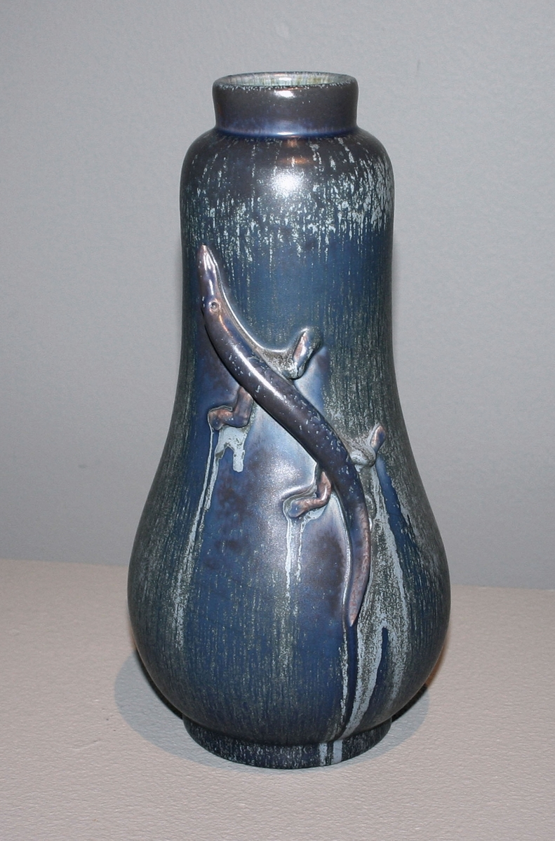 Vas, höjd 28 cm, blå och blågrön atomglasyr, GK15. Denna glasyr tillverkades/användes främst åren 1938-39. Formgivare Ewald Dahlskog, Bobergs Fajansfabrik, Gävle. Otydlig märkning.