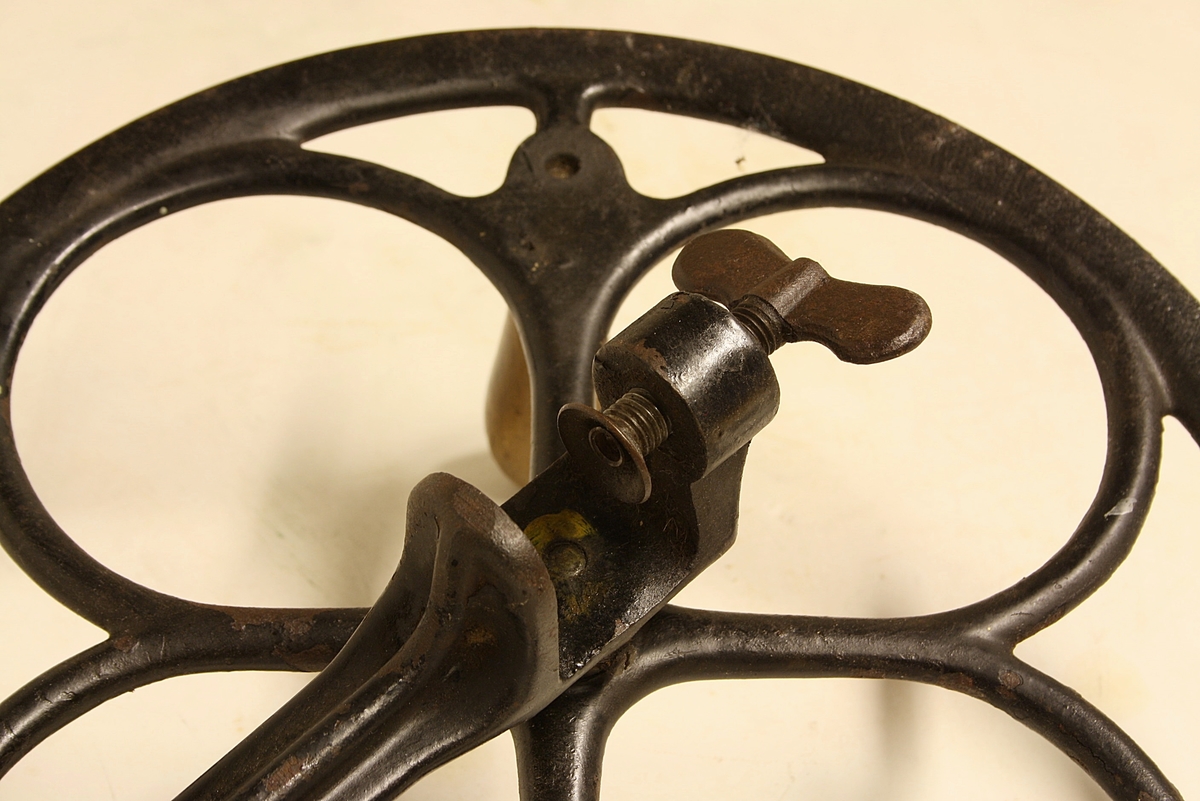 Mekanisk spolemaskin. Drivhjul med håndtak av tre. Håndtak skrudd fast. Skrutvinge av stål.