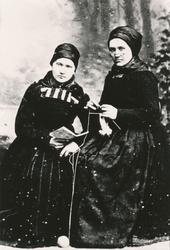 To kvinner hos fotografen. Den ene har strikketøy og den and