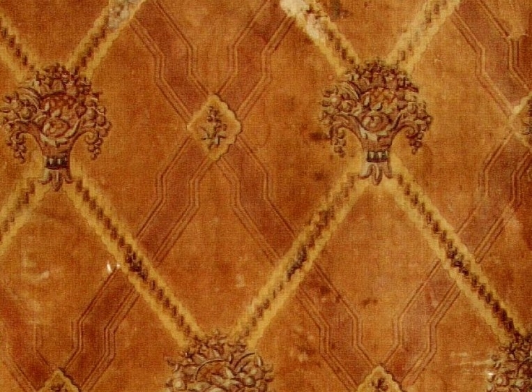 Ett dubbelt snedrutmönster dekorerat med en kärve i varannat  kryss. Tryck i grått och beige samt i två orangebruna nyanser.