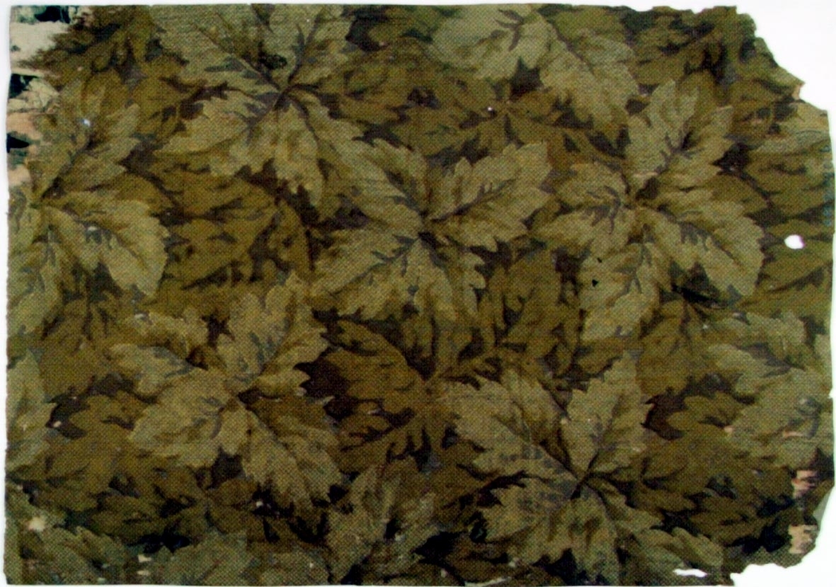 Tätt ytfyllande bladmönster i flera bruna nyanser. Övertryck med snedrutmönster.