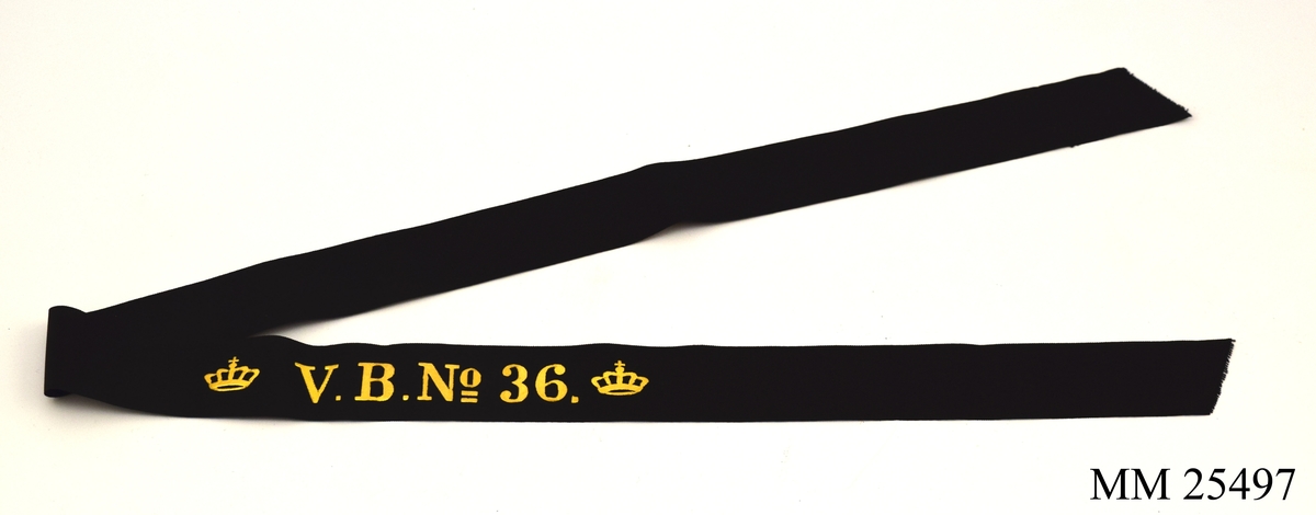 Mössband av svart sidenrips. Guldfärgad text, "V.B. NO 36", med två kronor på vardera sida.