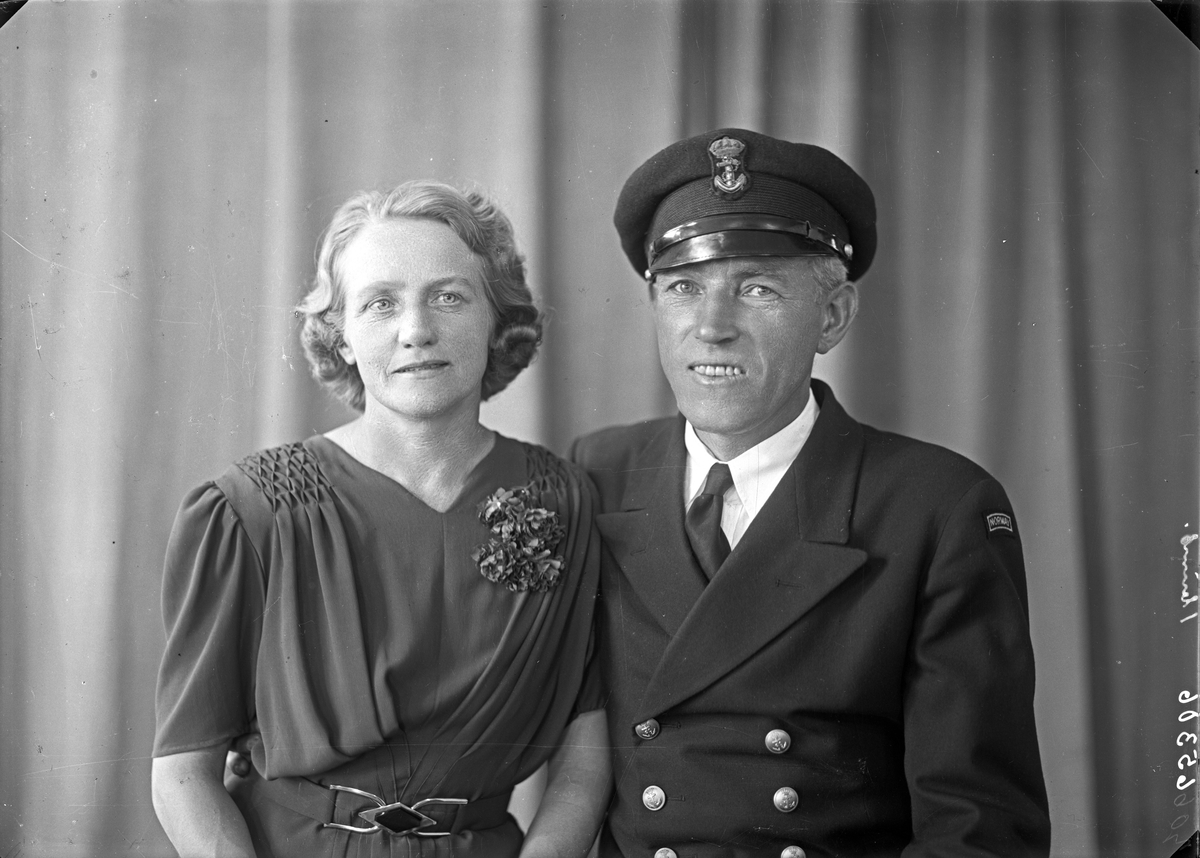 Gruppebilde. Familiegruppe på to. En kvinne og en mann i uniform. Bestillt av Vilh. Larsen.