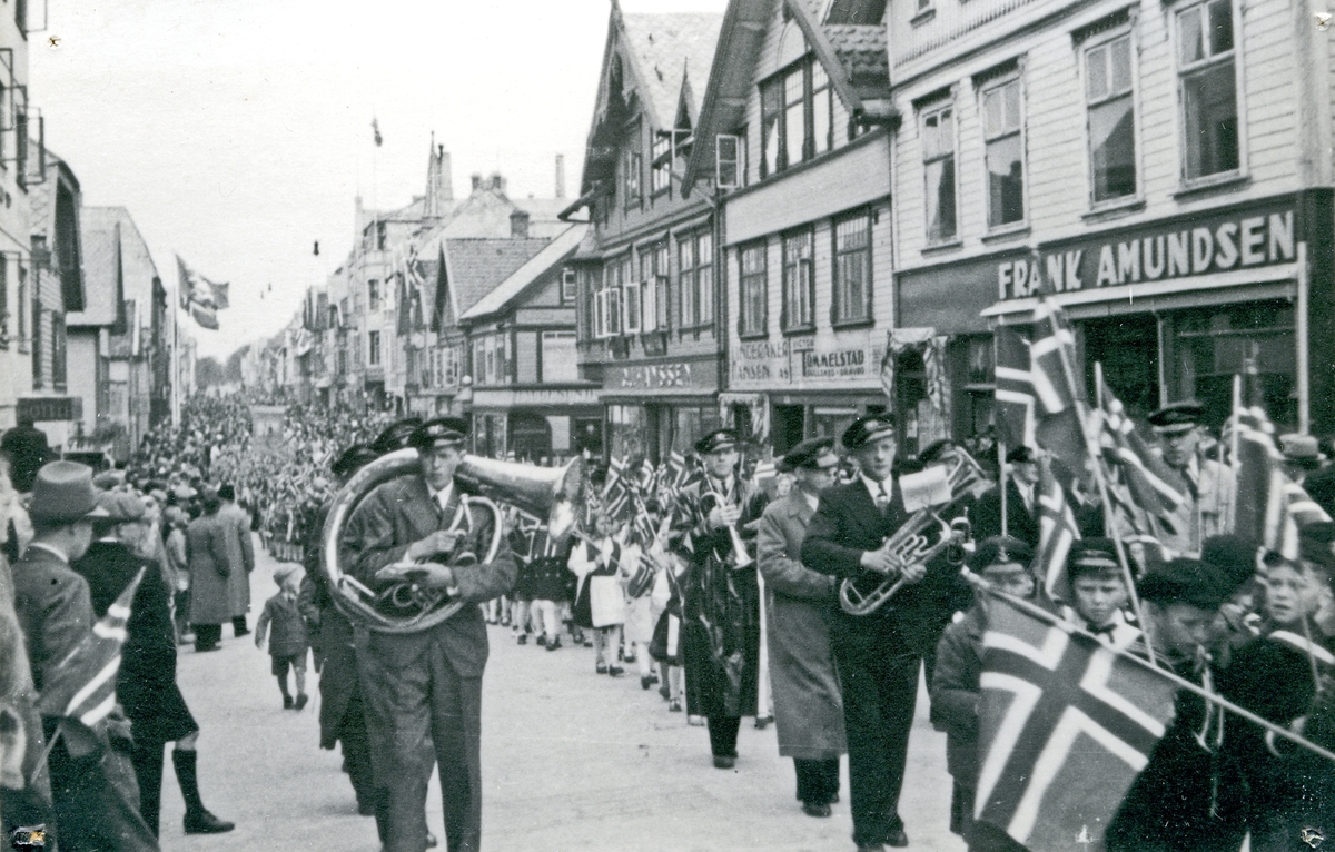 17. mai tog i Haraldsgt. Musikk-korps. Barn med flagg. Hull etter stifter i hjørnene.