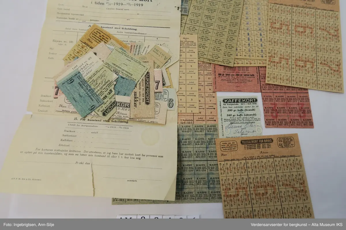 Konvolutt med mange rasjoneringskort. Det er kort for blant annet brød, erter, kaffe og sukker.