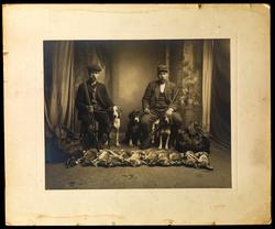 Studiofoto. To menn med våpen, hund og fangst (harer og rype